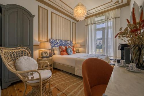 a bedroom with a bed and a table and chairs at Solar dos Poetas in Lisbon