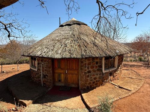 a small stone building with a grass roof at Mukuni Villas in Livingstone