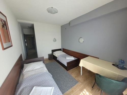 a room with two beds and a desk in it at Willa Orle Gniazdo in Szczyrk