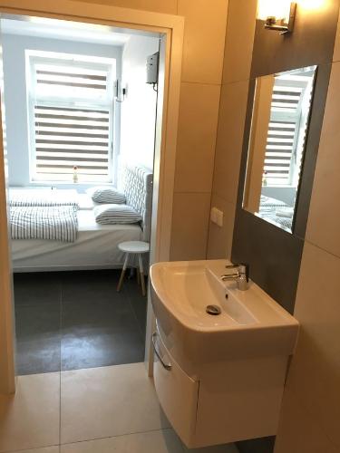 a bathroom with a sink and a bedroom with a bed at Panorama Gdynia Rooms in Gdynia