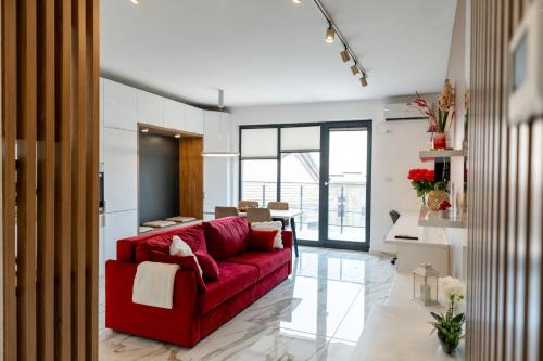 a living room with a red couch and a table at Elegance Rezidence in Arad