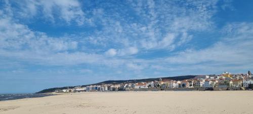 a view of a beach with buildings in the background at Comfortable rustic house with spacious garden near the beach in Figueira da Foz