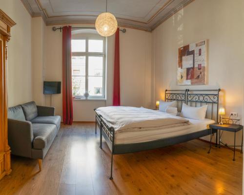 a bedroom with a bed and a couch and a window at Albergo-Toscana in Bad Schandau