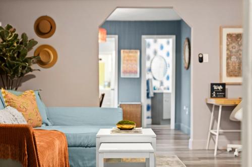 a living room with a blue couch and a table at The Blue Bungalow - Peaceful, Porch, Hot Tub, Downtown in Orlando