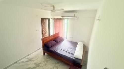 a wooden bed in a room with a window at S ROOMs in Pithāpuram