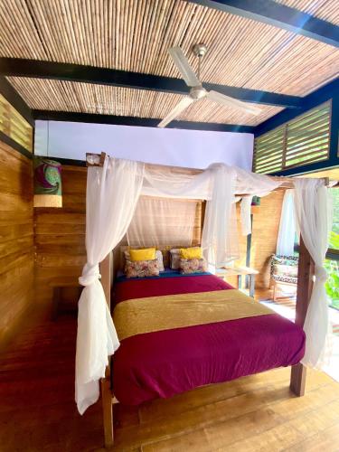 a bedroom with a bed with a canopy at La Shamana - Ecological Concept in Jungle in Cahuita