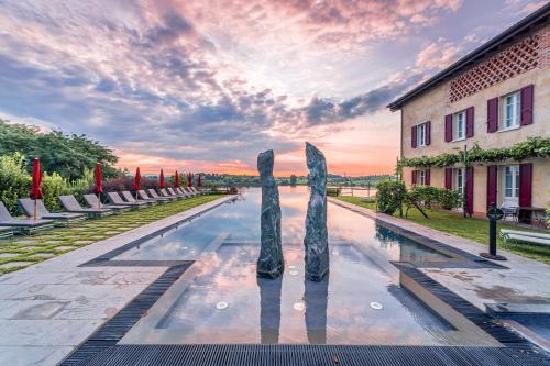 a pool with a sculpture in front of a building at Le Ali Del Frassino in Peschiera del Garda