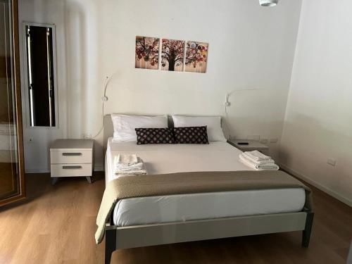 a bedroom with a large bed with two paintings on the wall at Villa Mia in Seneghe