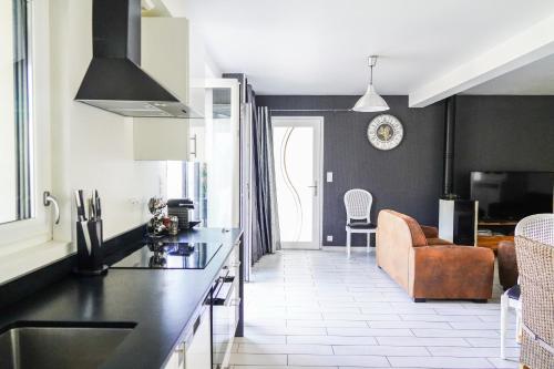 a kitchen with a counter top and a living room at Les Bleuets - Erdivines in Erdeven