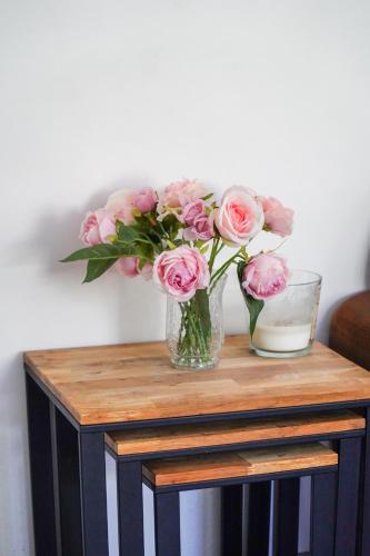 a vase of pink roses sitting on a table at Les Bleuets - Erdivines in Erdeven