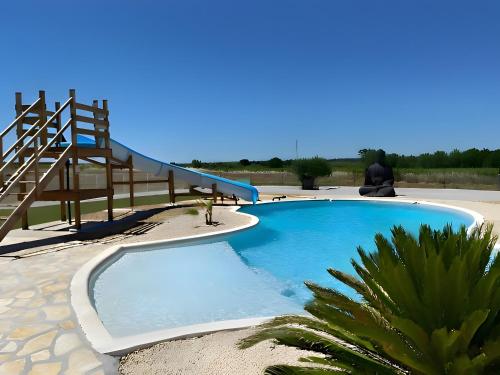 ein großes Schwimmbad mit einer Treppe neben einem Strand in der Unterkunft Gîte Du Midi - La Noria in Cazouls-lès-Béziers