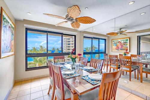 a dining room with a table and chairs and windows at The Kaanapali Alii By Maui Resort Rentals in Lahaina