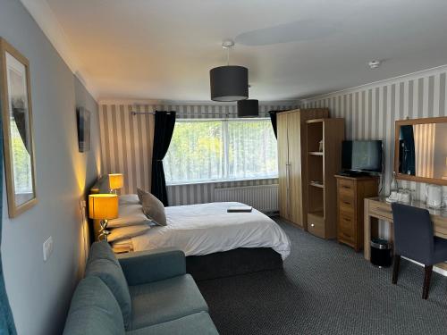 a hotel room with a bed and a couch at Rothay House in Ambleside