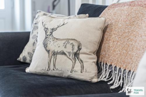 a drawing of a deer on a pillow on a couch at Lisa's House in Leek