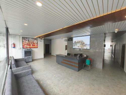 a living room with a couch and a tv on the wall at Raja Palace in Ayodhya