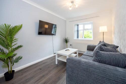 a living room with a couch and a table at Bright and Modern 2 Bed Home w Garden in Liverpool in Liverpool