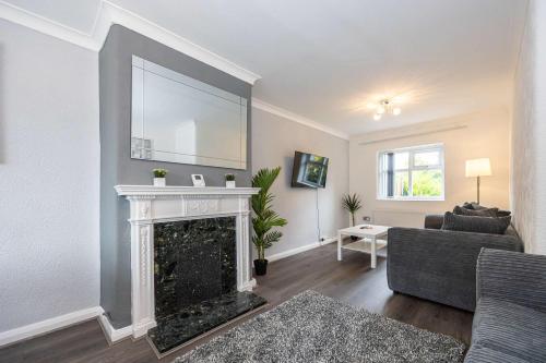 a living room with a fireplace and a couch at Bright and Modern 2 Bed Home w Garden in Liverpool in Liverpool