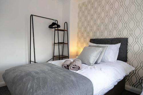 a bedroom with a bed with white sheets and a headboard at Bright and Modern 2 Bed Home w Garden in Liverpool in Liverpool