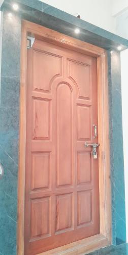 a wooden door in the middle of a room at Venya Vihar a Deluxe 2 BHK Home Stays in Visakhapatnam