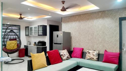 a living room with a couch with colorful pillows at Venya Vihar a Deluxe 2 BHK Home Stays in Visakhapatnam