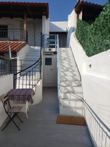 a stairway with a table and a chair on a house at Old soul, Sea views in Dhërmi
