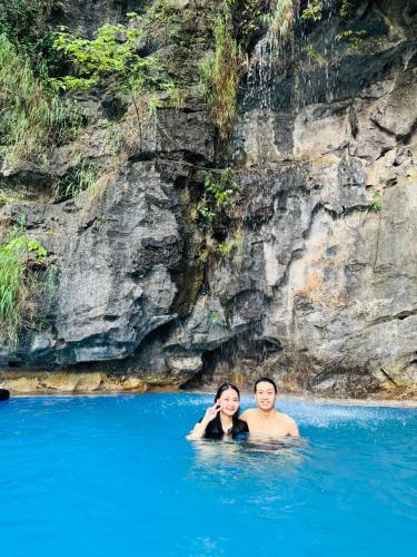 a man and a woman swimming in the water at Green Valley Homestay - Thung Lũng Xanh in Nguyên Ngoại