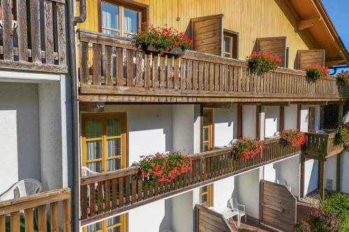 a building with wooden balconies with flowers on them at Landhotel Tannenhof in Spiegelau