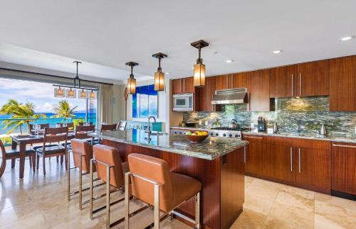 a kitchen with a bar and a dining room at Honua Kai Resort And Spa By Maui Resort Rentals in Lahaina