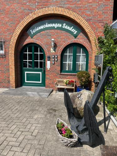 a building with a statue in front of it at Ferienwohnung Tee Tied in Dornumersiel