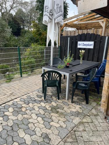a table and chairs and an umbrella on a patio at Ferienwohnung Tee Tied in Dornumersiel