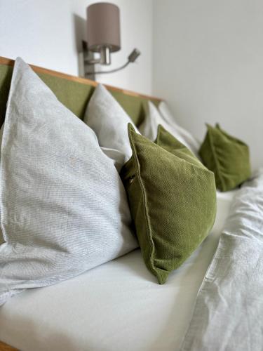 a white couch with green pillows on it at Apartment Postplattler in Hof bei Salzburg
