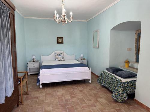 a bedroom with a bed and a chandelier at Il Castelletto Casa Vacanza in Poggio San Lorenzo