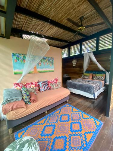 a bedroom with two beds and a rug at La Shamana - Ecological Concept in Jungle in Cahuita
