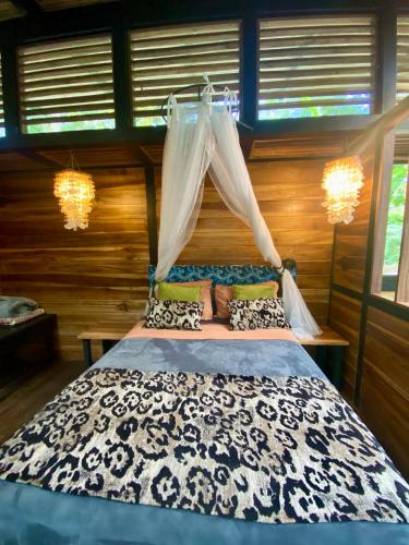 a bedroom with a bed with a black and white comforter at La Shamana - Ecological Concept in Jungle in Cahuita