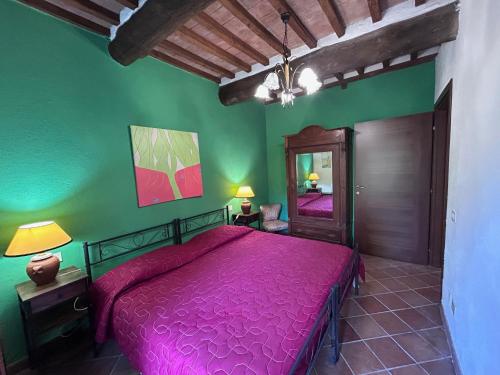 a bedroom with a pink bed and a mirror at Agriturismo San Ansanino in Pari