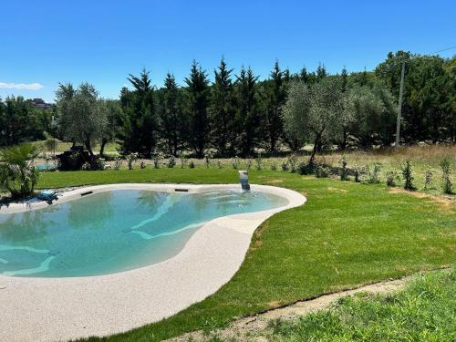 a swimming pool in a grassy yard with a garden at Agriturismo San Ansanino in Pari