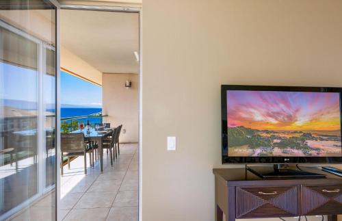 a living room with a flat screen tv on a wall at Honua Kai Resort And Spa By Maui Resort Rentals in Lahaina