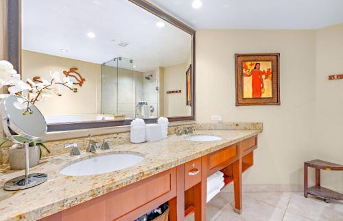a bathroom with two sinks and a large mirror at Honua Kai Resort And Spa By Maui Resort Rentals in Lahaina