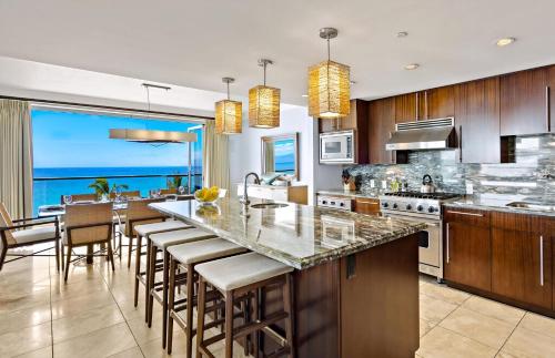 a kitchen with a large island with bar stools at Honua Kai Resort And Spa By Maui Resort Rentals in Lahaina