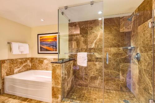 a bathroom with a tub and a shower stall at Honua Kai Resort And Spa By Maui Resort Rentals in Lahaina