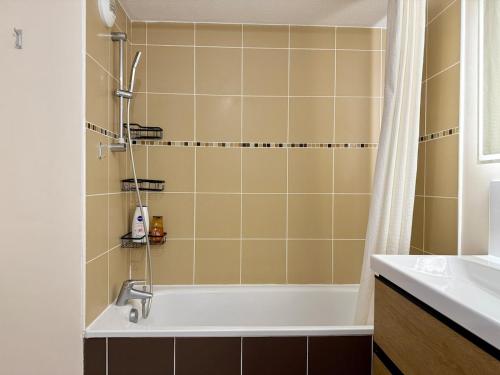 a bathroom with a bath tub and a sink at Le refuge douillet de Colomiers - proche Airbus in Colomiers