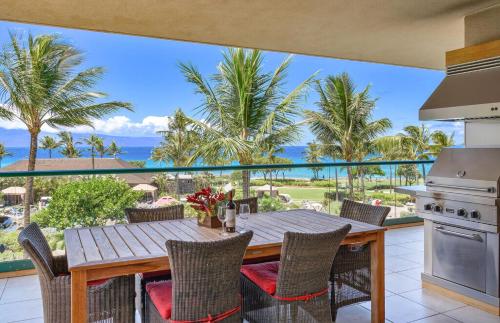 a table and chairs on a balcony with a view of the ocean at Honua Kai Resort And Spa By Maui Resort Rentals in Lahaina