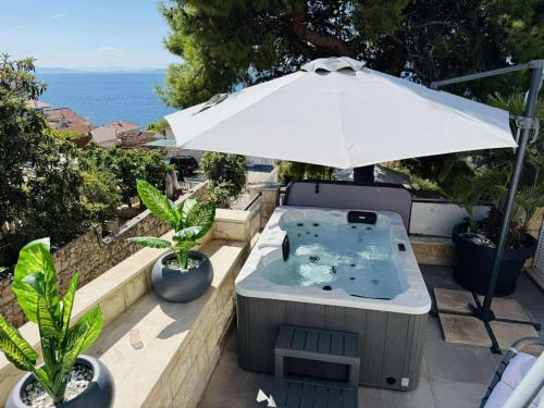 a hot tub sitting under an umbrella on a patio at Villa Sirenis in Trogir
