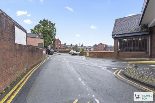 an empty street next to a brick building at Lisa's House in Leek