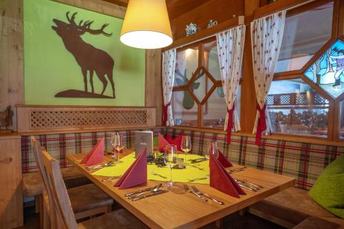 a table in a restaurant with a deer on the wall at Landhotel Tannenhof in Spiegelau