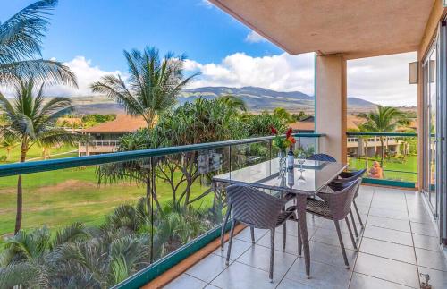 a balcony with a table and chairs and palm trees at Honua Kai Resort And Spa By Maui Resort Rentals in Lahaina