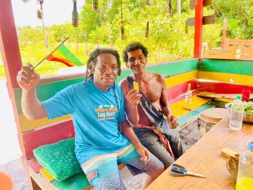 two men sitting at a table in a booth at Land of Promise - Reggae Escape in Zanderij