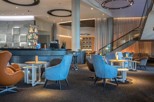 a restaurant with blue chairs and tables and a bar at ScanHotels City in Rostock