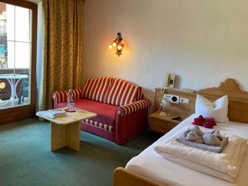 a hotel room with a bed and a couch at Hotel Metzgerwirt in Kirchberg in Tirol