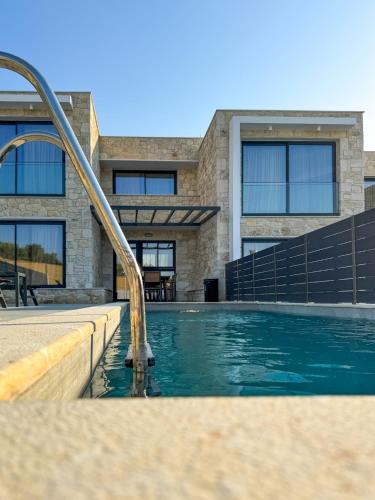 a swimming pool in front of a building at The Olive Path in Kalandra